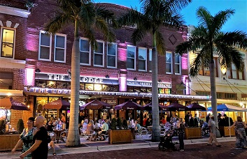 Bild der am Abend beleuchteten Gebäude in der Hautpstrasse durch die Fussgängerzone von Fort Myers Downtown