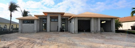 Picture showing the Construction of a home in the rough stage with the roof on