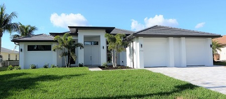 Bild eines Neubaus in Cape Coral Florida - Ansicht vorne des fertigen Hauses mit Gartenanlage