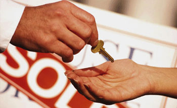 Picture of a key being handed over after a closing